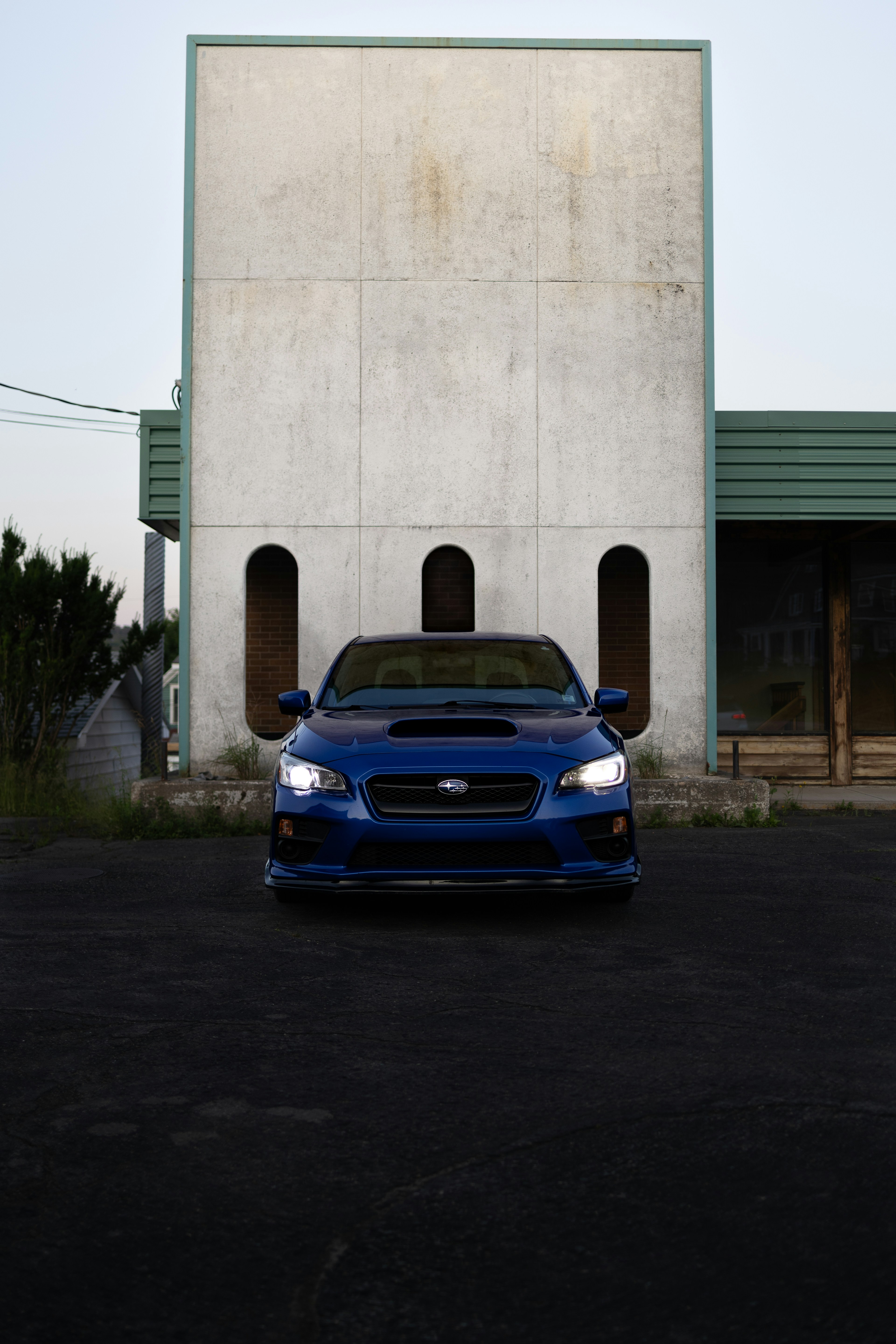 A blue car parked in front of a building