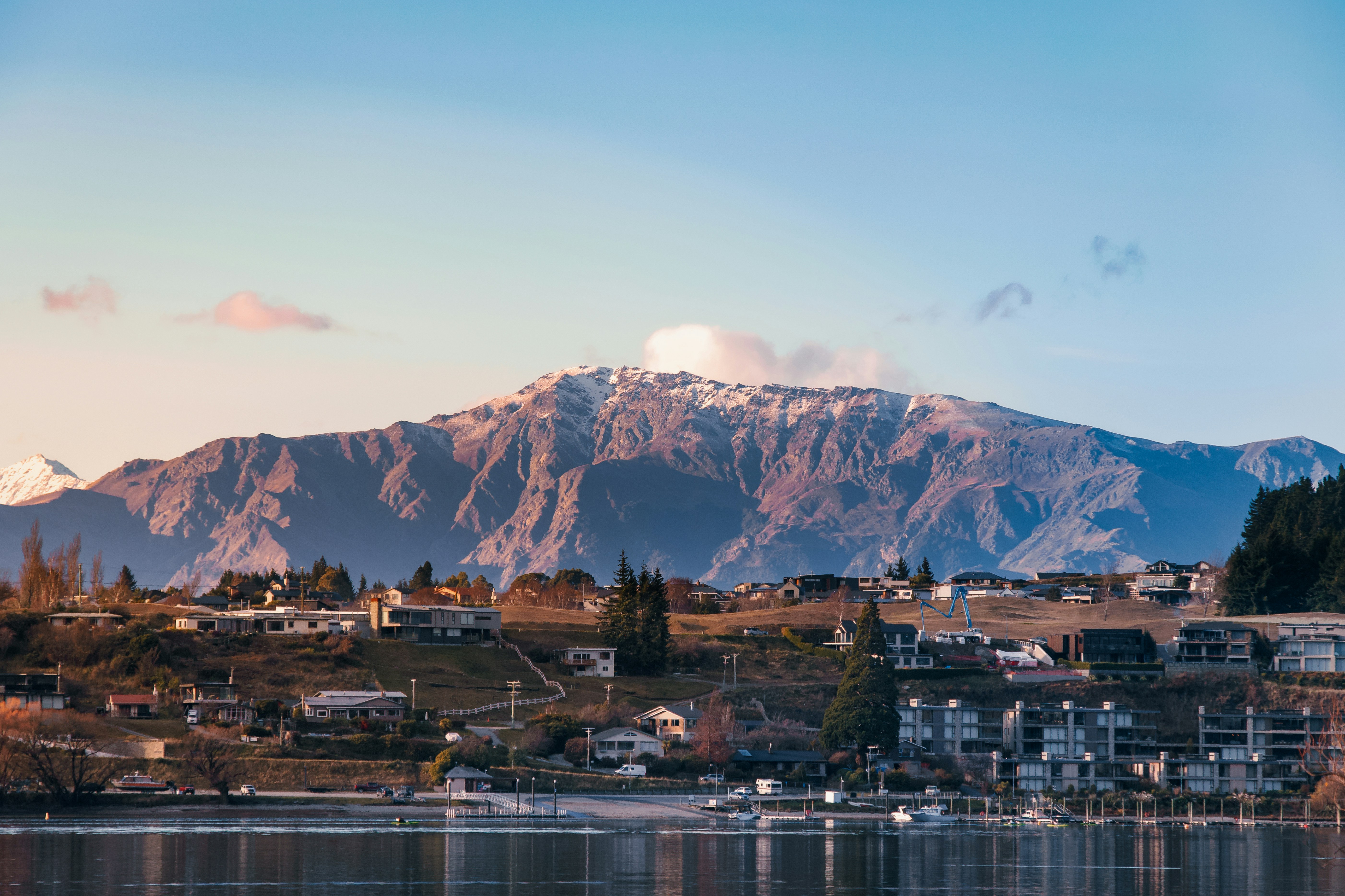 A view of a town on a lake with mountains in the background