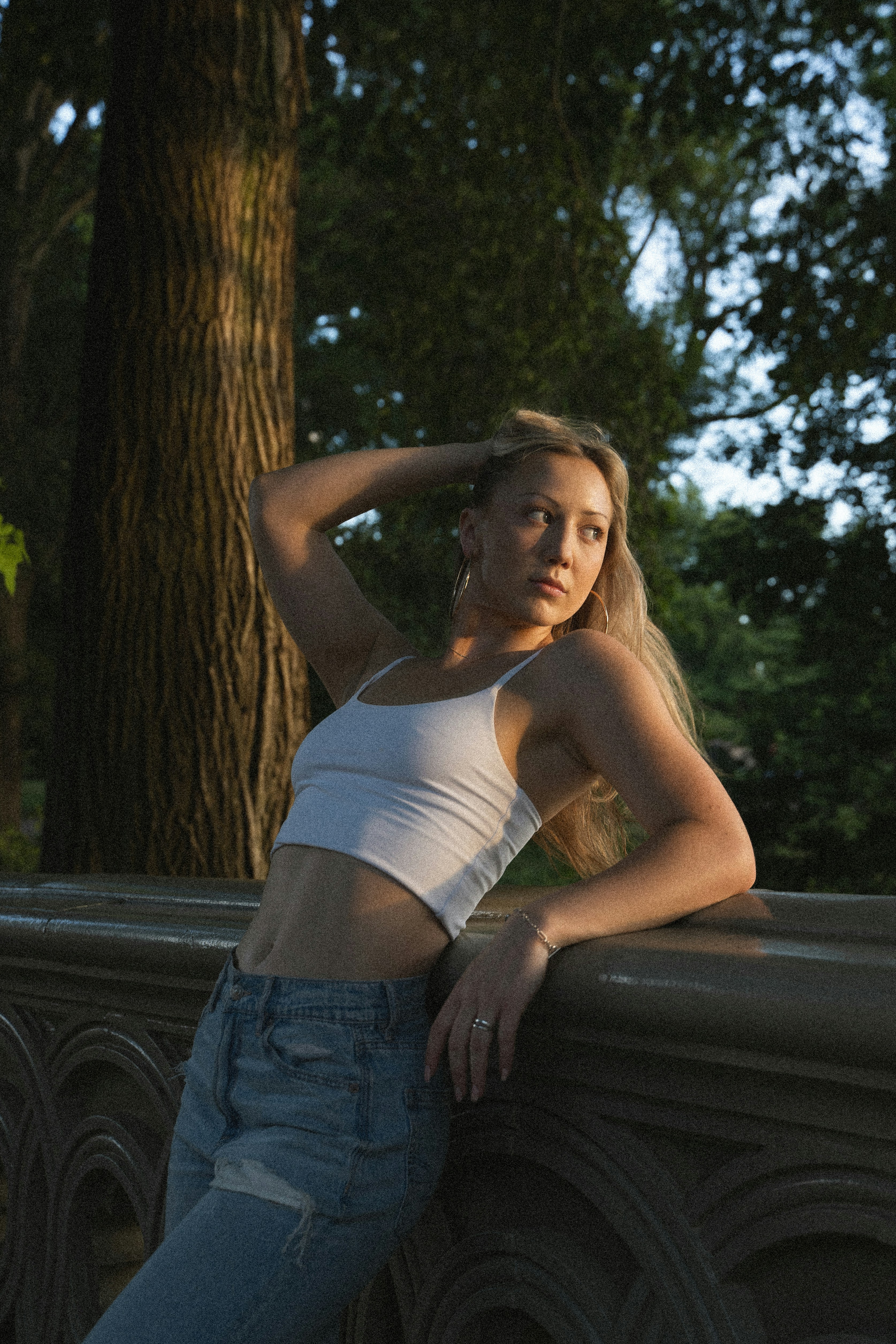 A woman leaning on a fence with her hand on her head