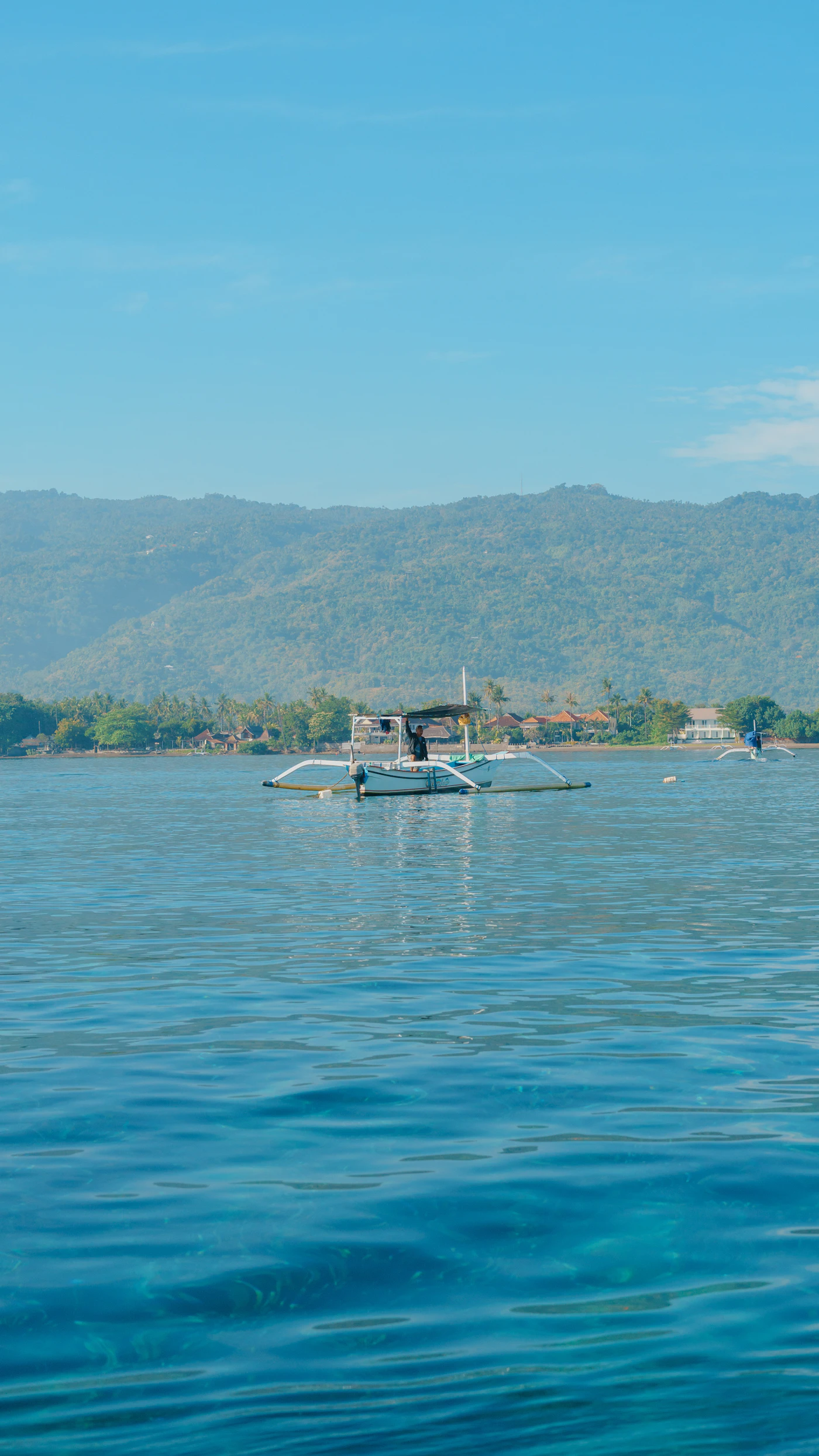 Traditional jukung boats resting on the calm water along the Lovina coast