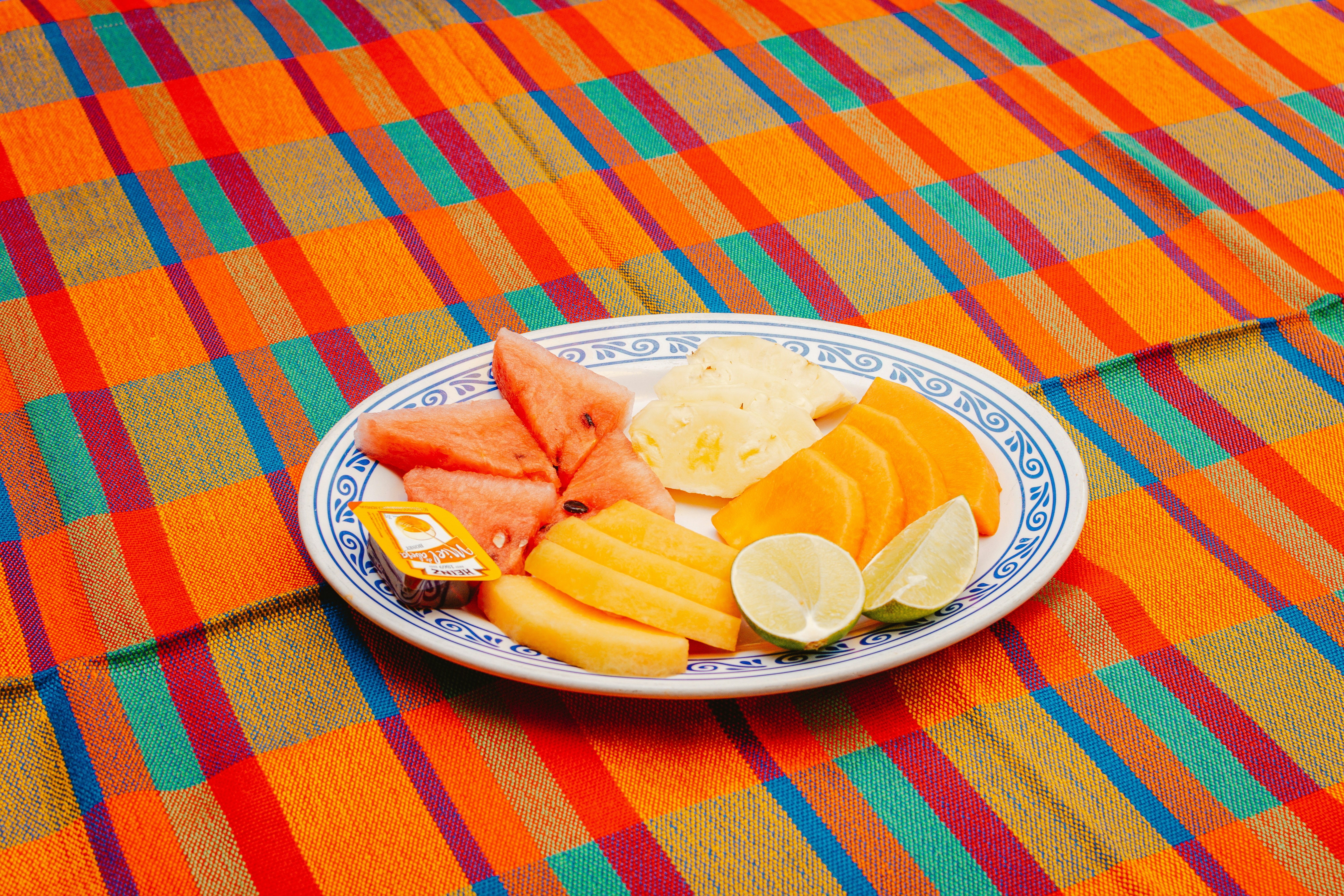 Plate of tropical fruit on a striped cloth