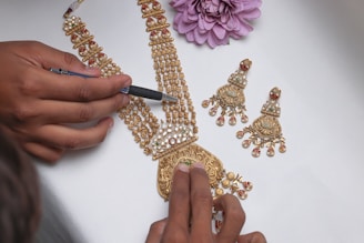 A woman is working on a gold necklace