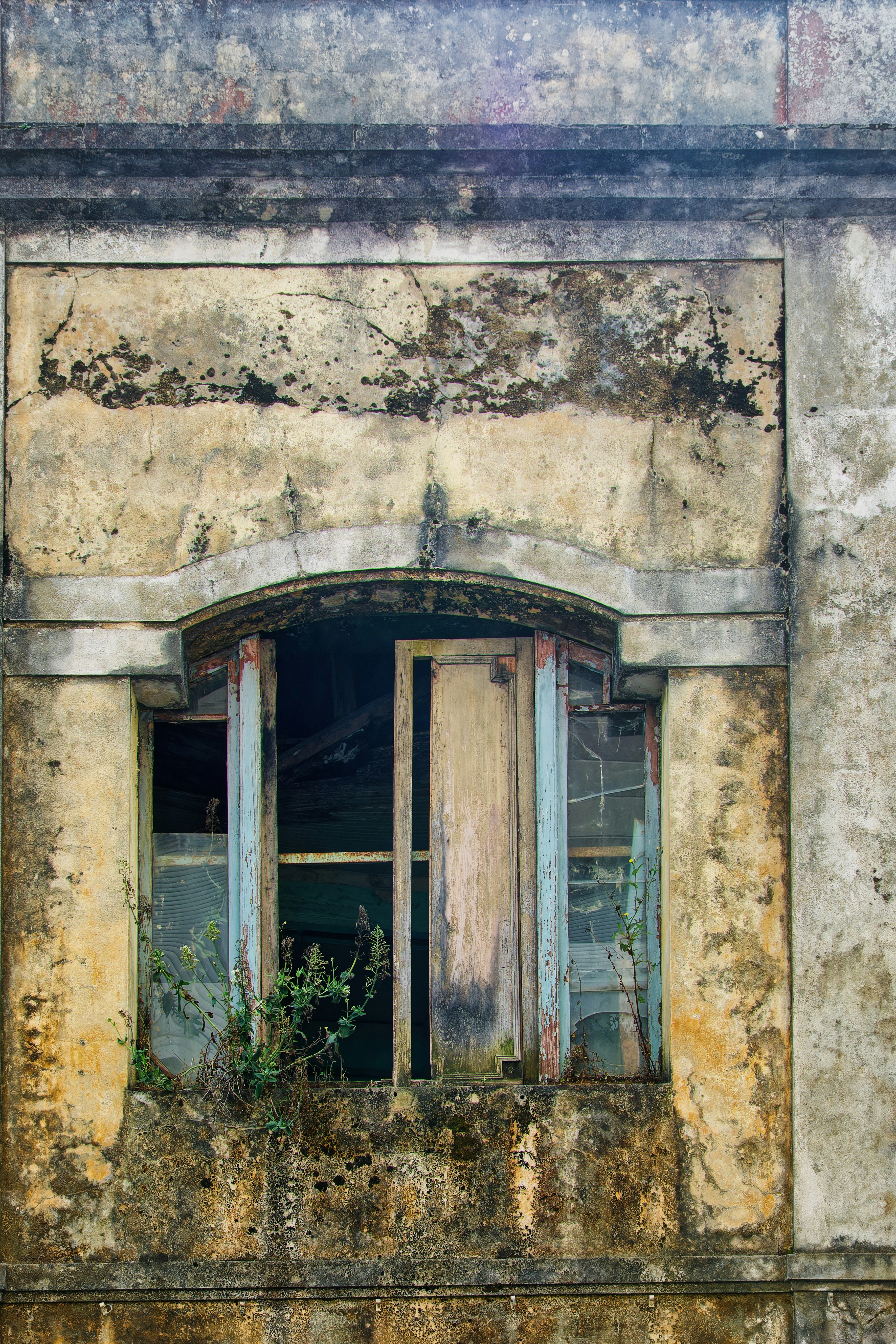 An old building with a broken window and shutters