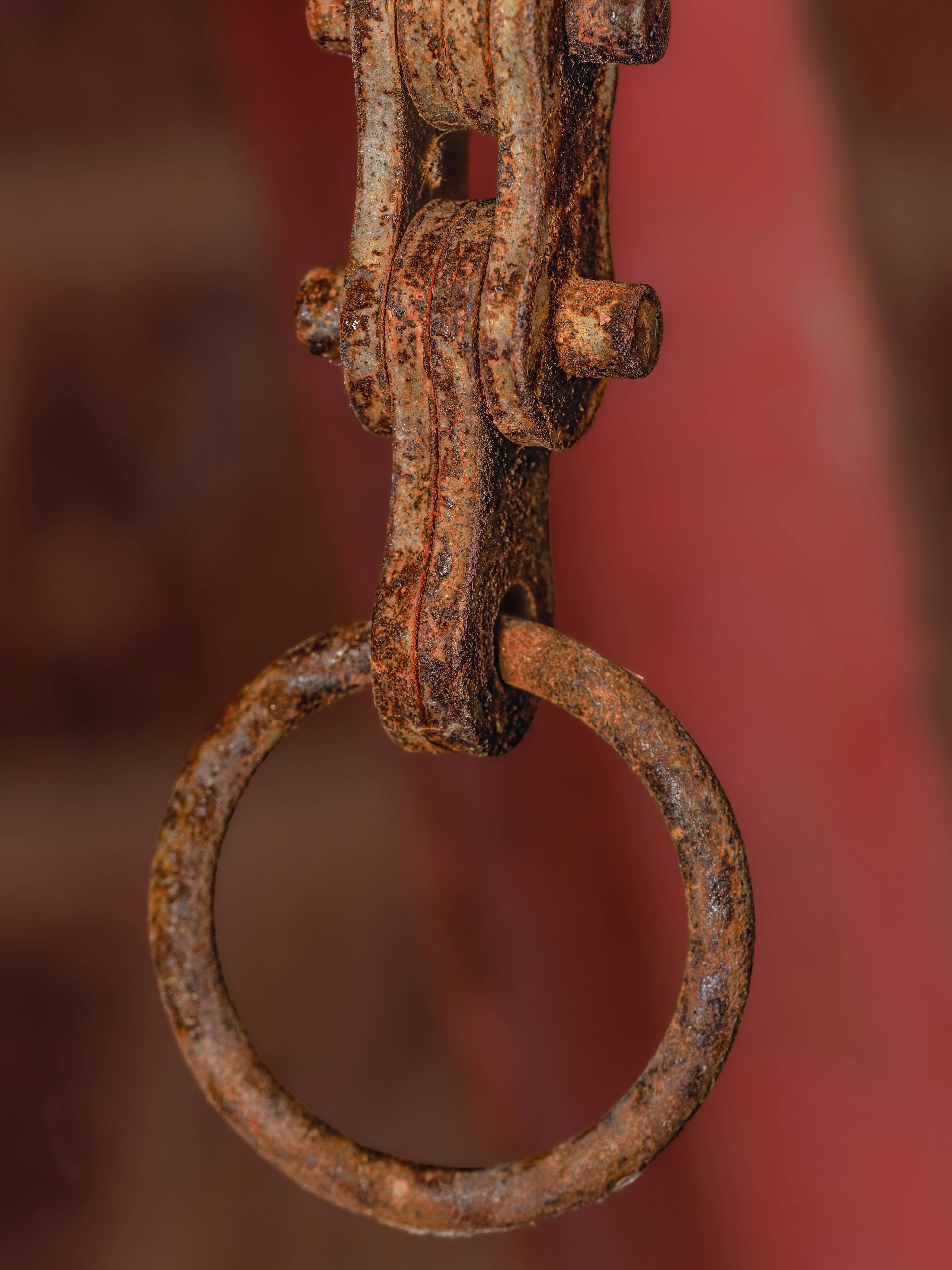 A rusted metal object hanging from a hook