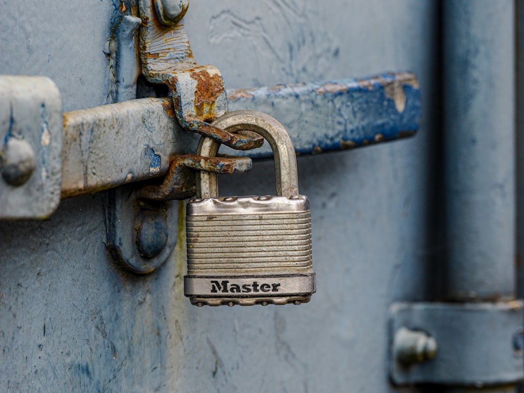 A padlock attached to a door with the word master written on it, old rusty padlock on the door