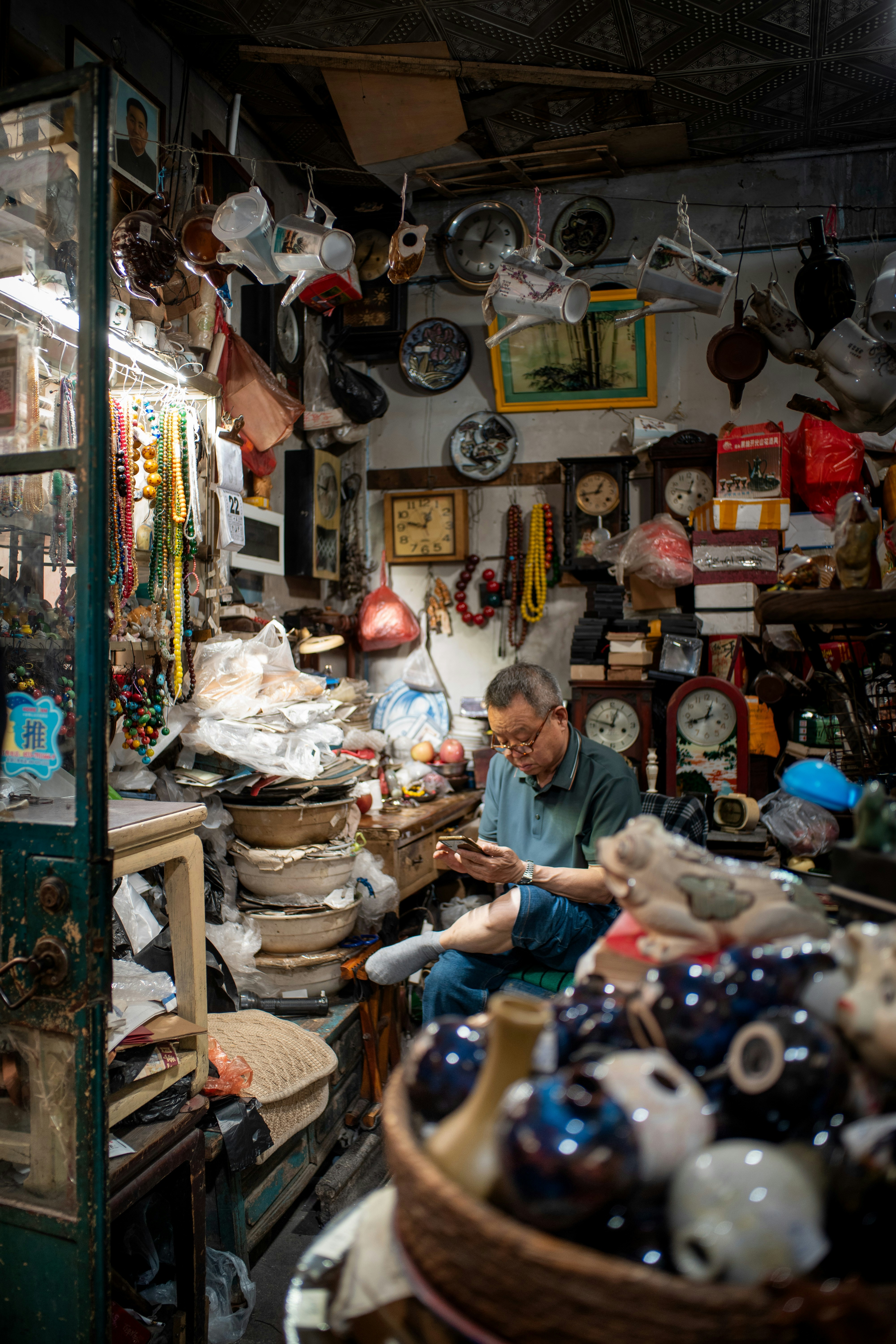 A man sitting in a room filled with lots of items