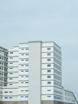 A tall white building sitting next to a highway