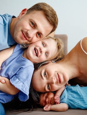 A man and two children laying on a couch