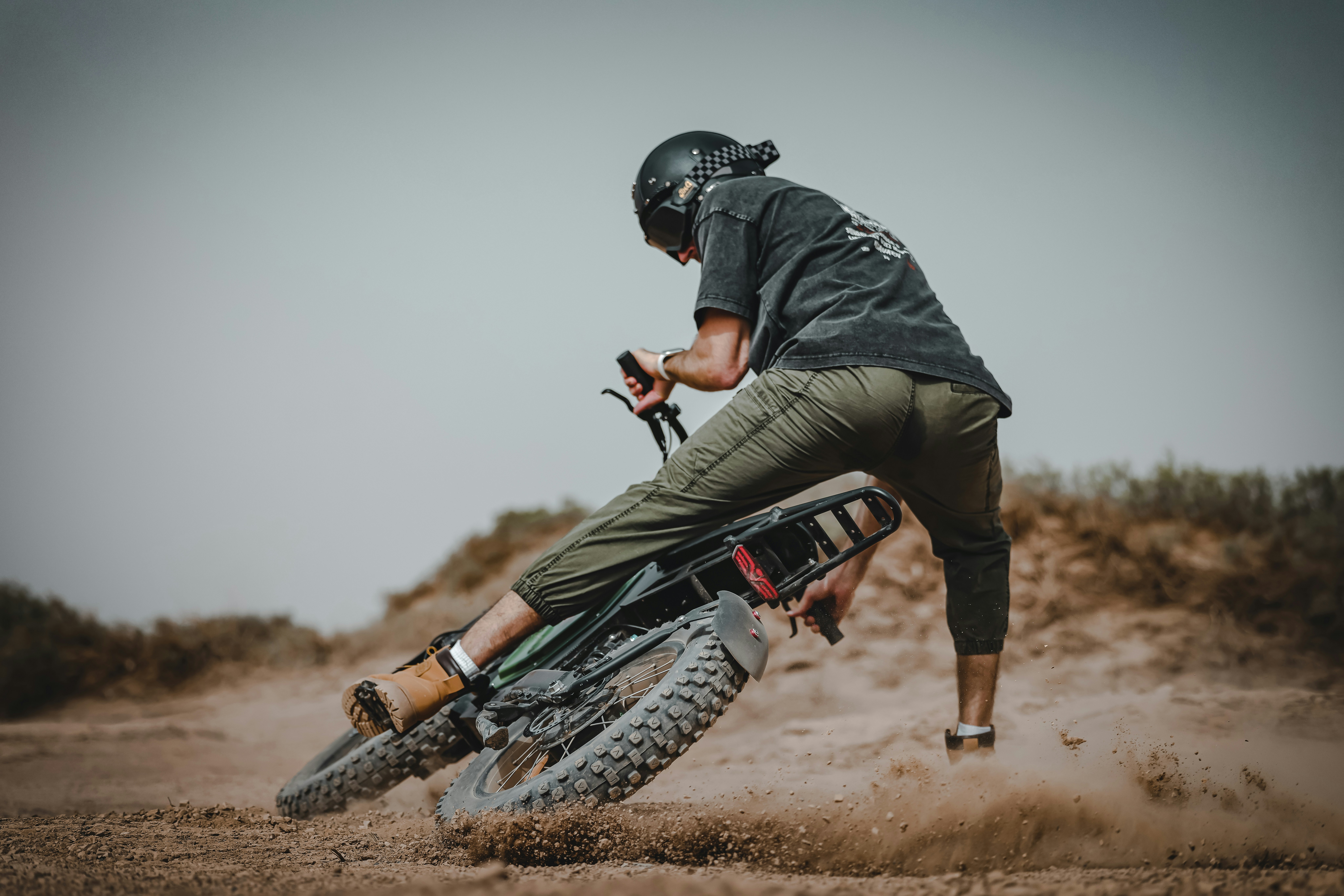 A man riding a dirt bike on top of a dirt field