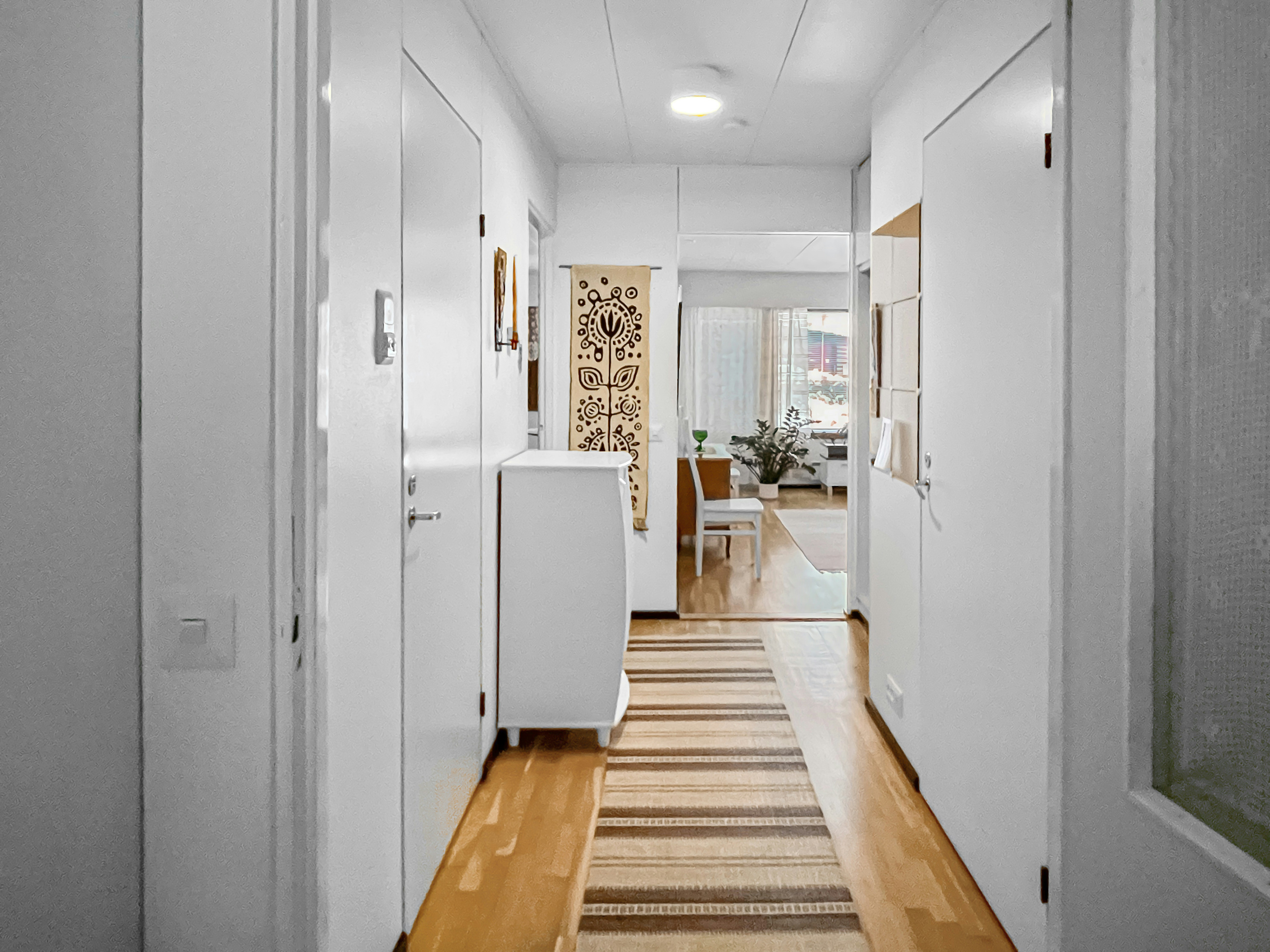 A long hallway with white walls and wooden floors photo Free Indoors