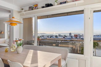 A dining room table with chairs and a view of a city