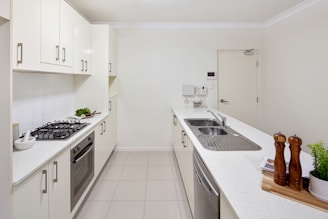 A kitchen with a stove top oven next to a sink