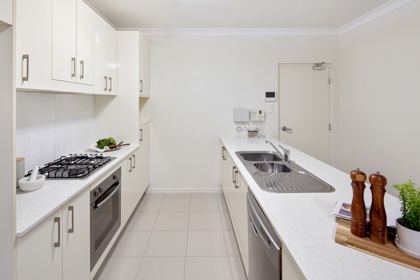A kitchen with a stove top oven next to a sink