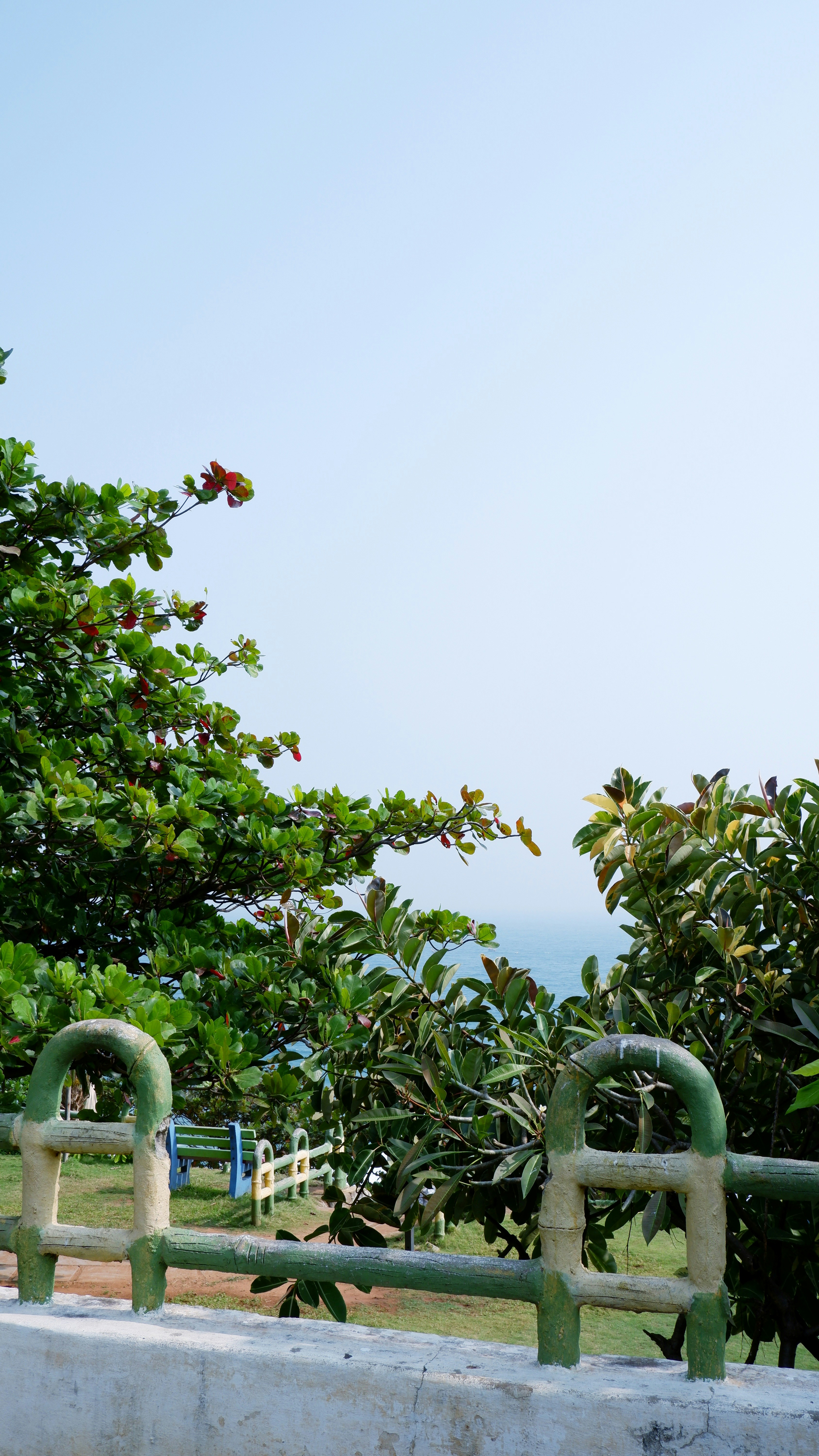 A white wall with a green metal railing