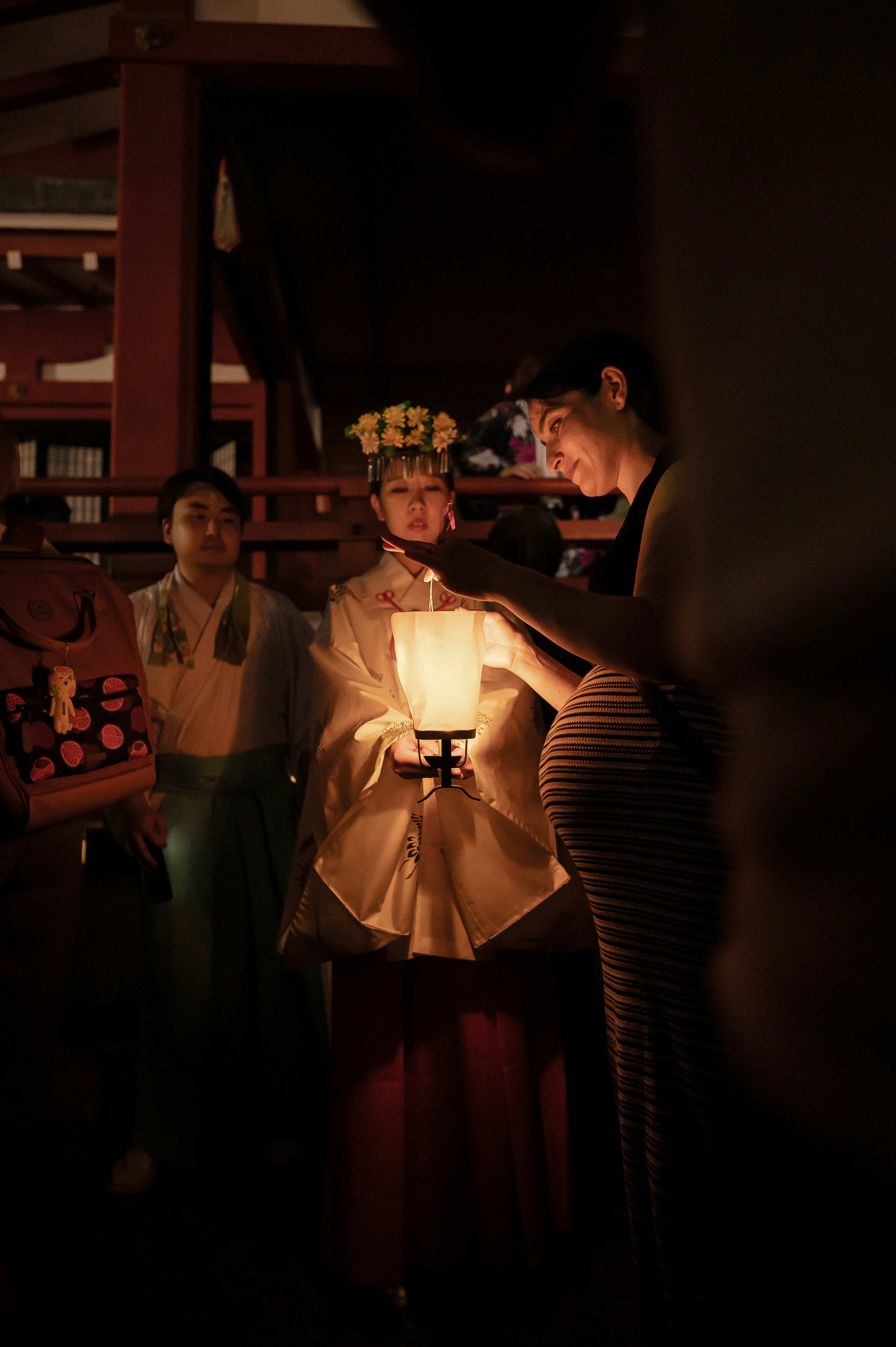 A group of people standing around a lamp