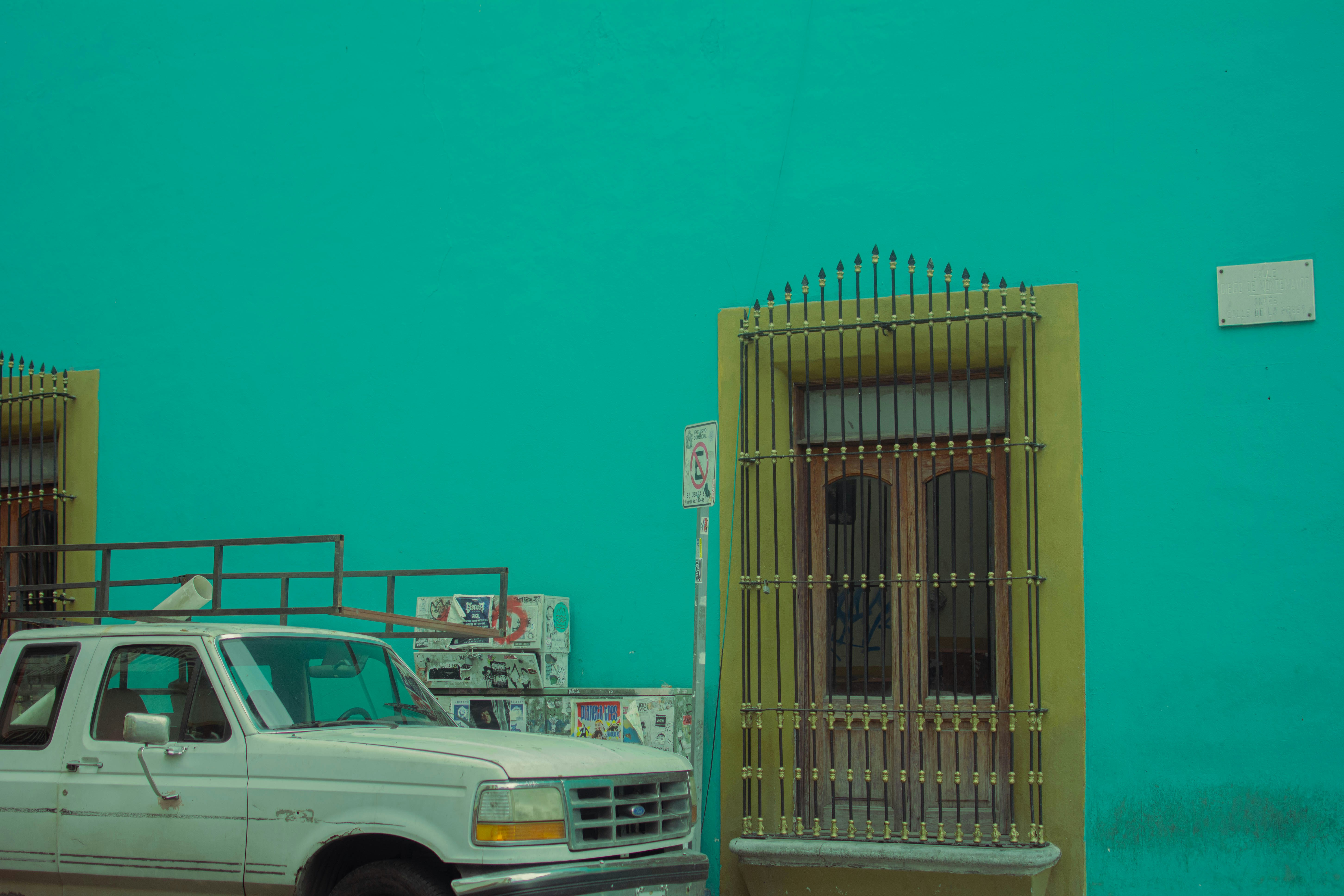 A white truck parked in front of a blue building