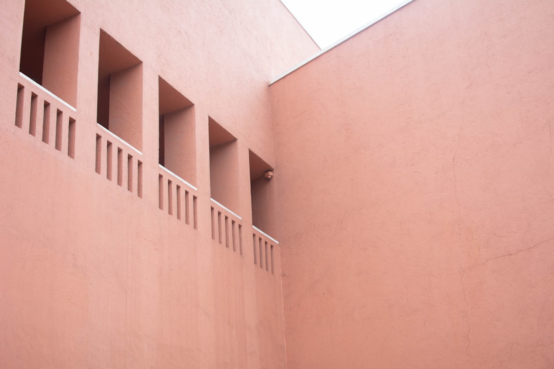 A pink building with a clock on the side of it,
