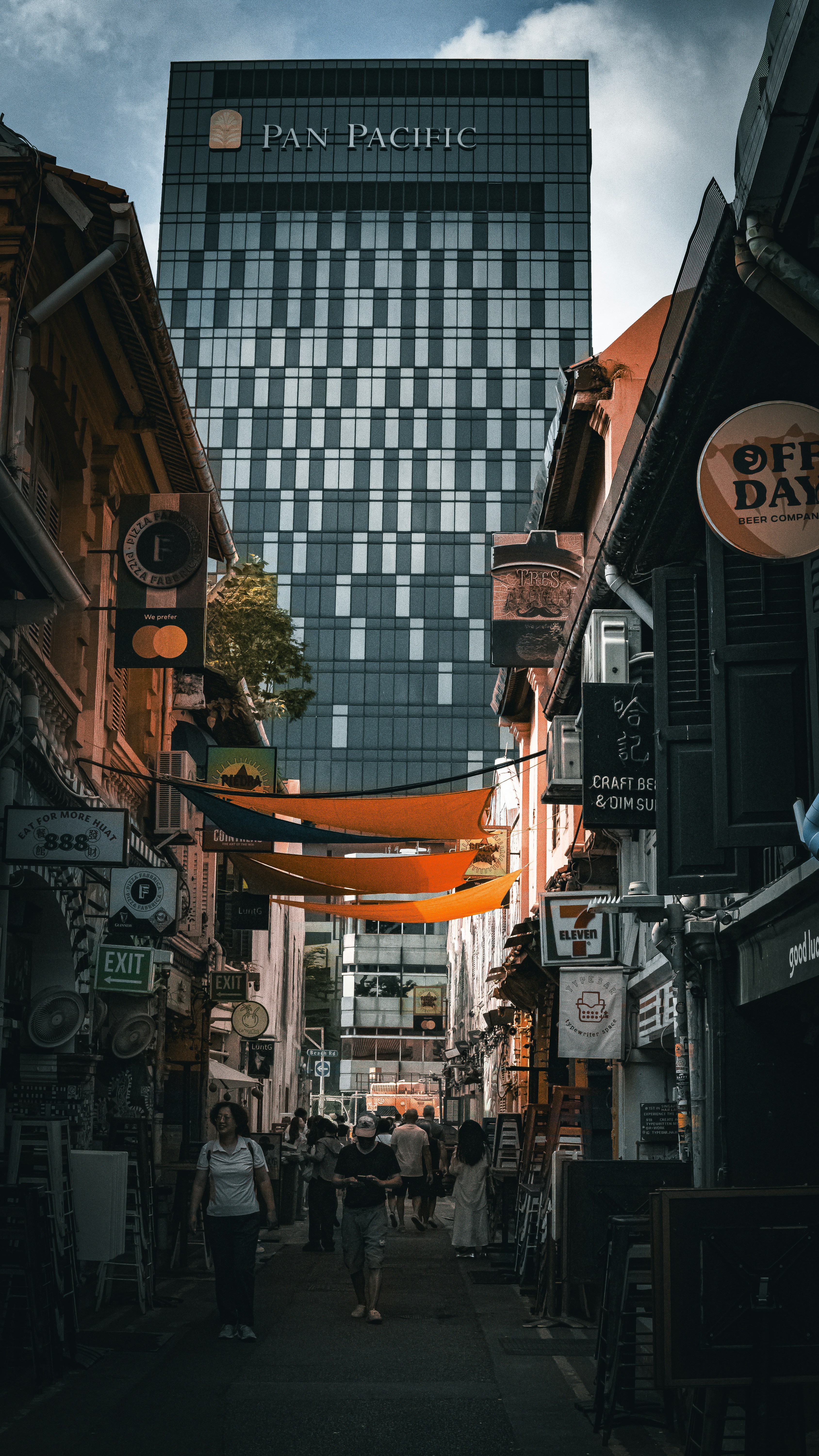 A narrow city street with a tall building in the background