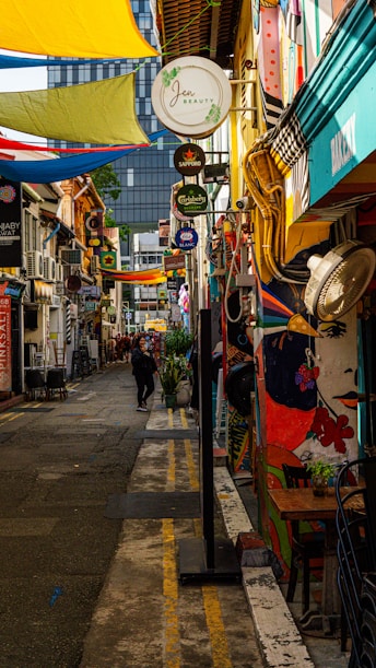 A narrow city street lined with lots of shops
