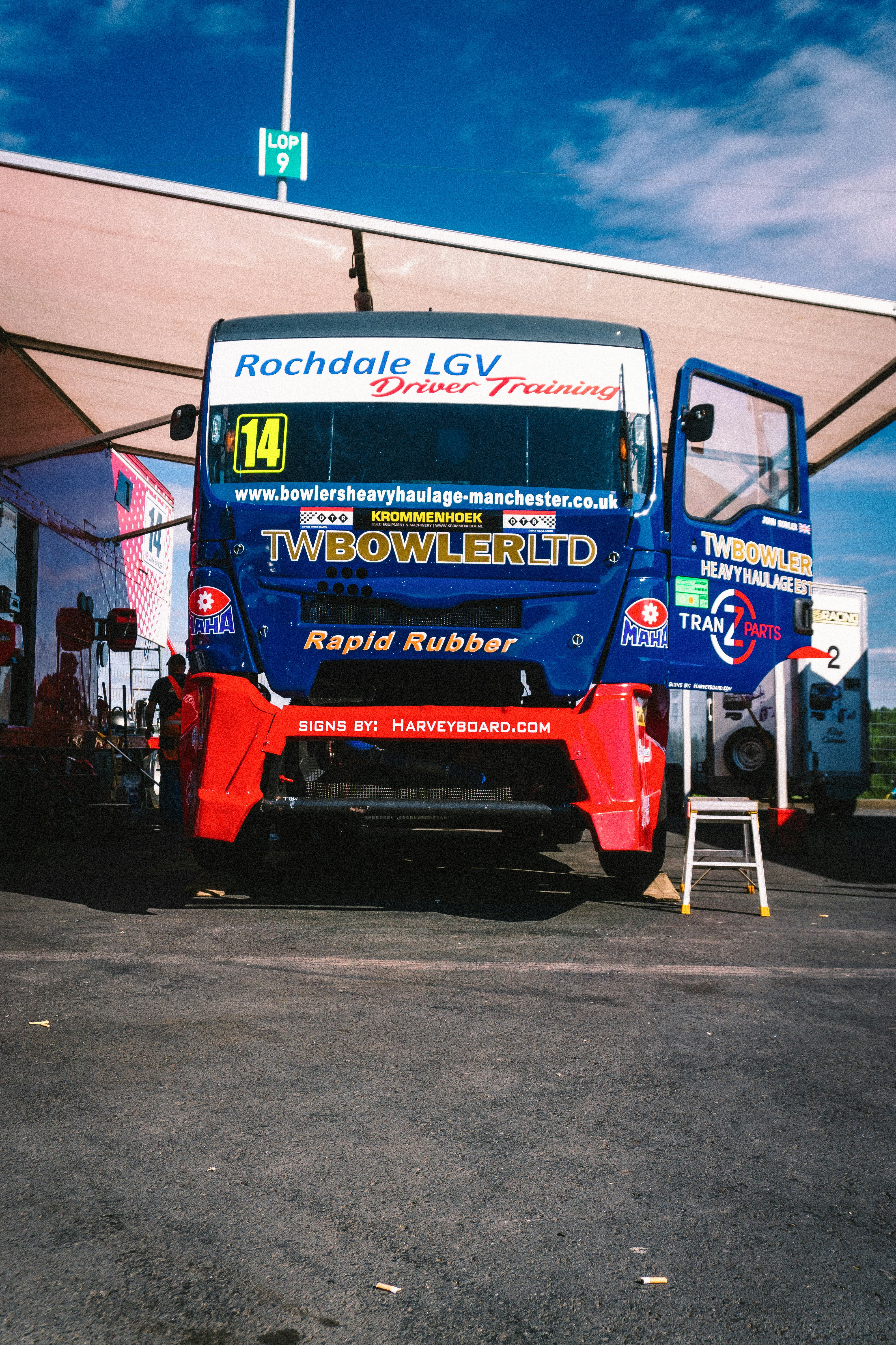 A blue and red bus parked in front of a building photo – Free ...