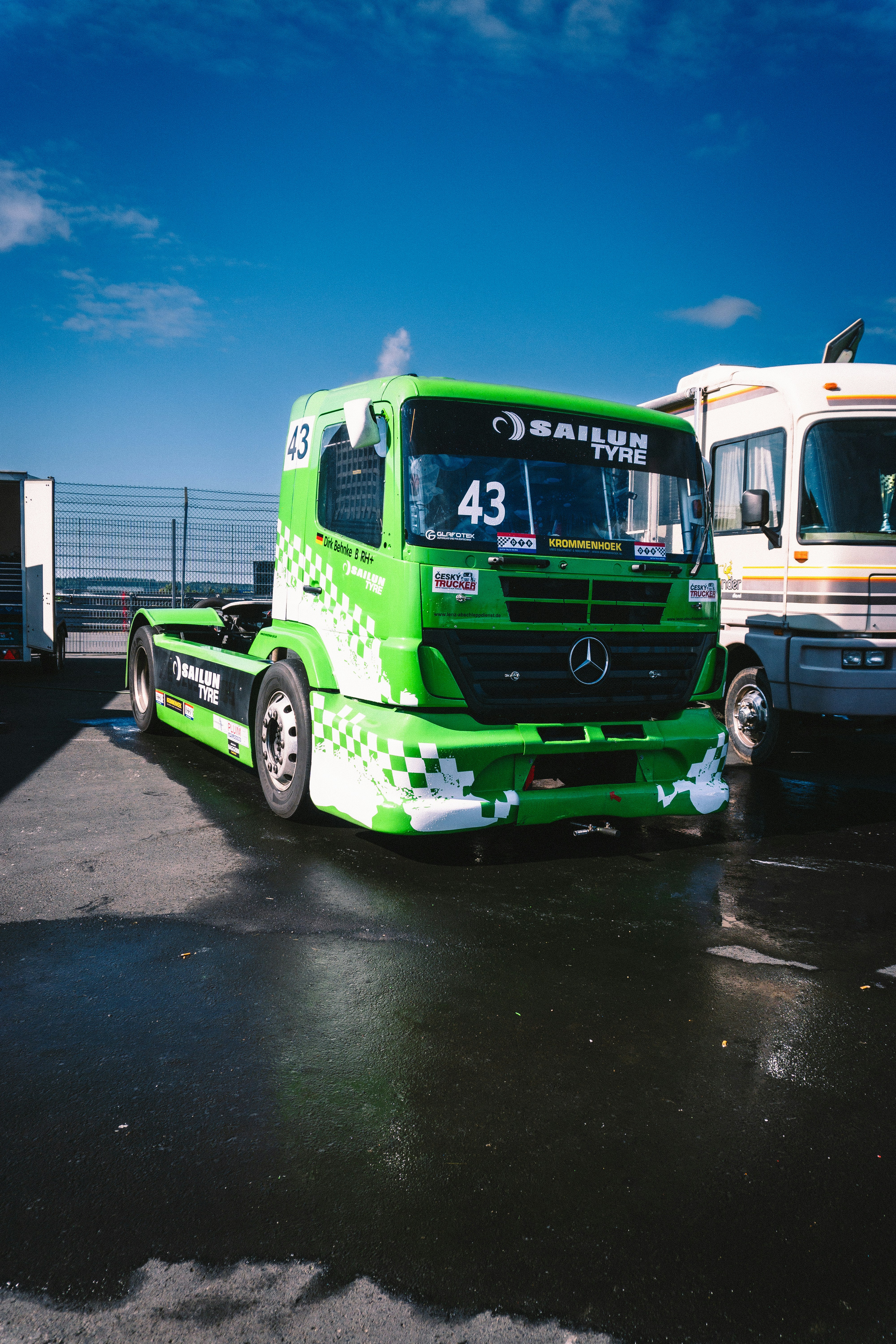 A couple of green trucks parked next to each other