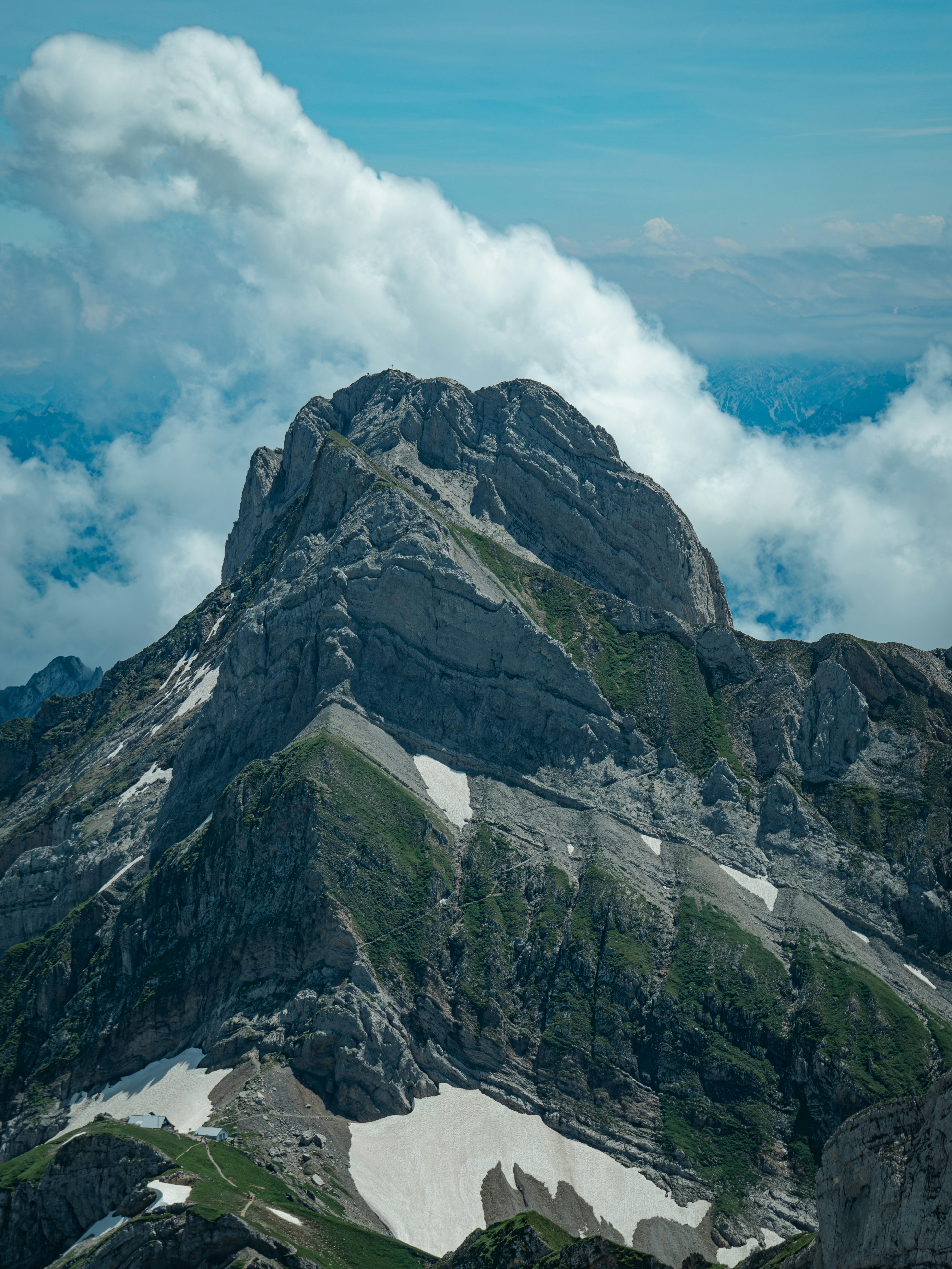 A very tall mountain covered in snow and clouds