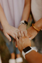 A group of people standing next to each other holding hands