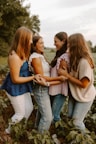 A group of young women standing next to each other in a field