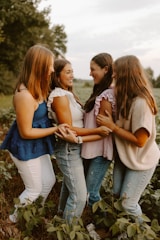 A group of young women standing next to each other in a field