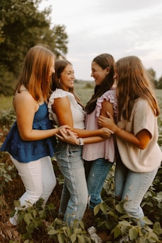 A group of young women standing next to each other in a field