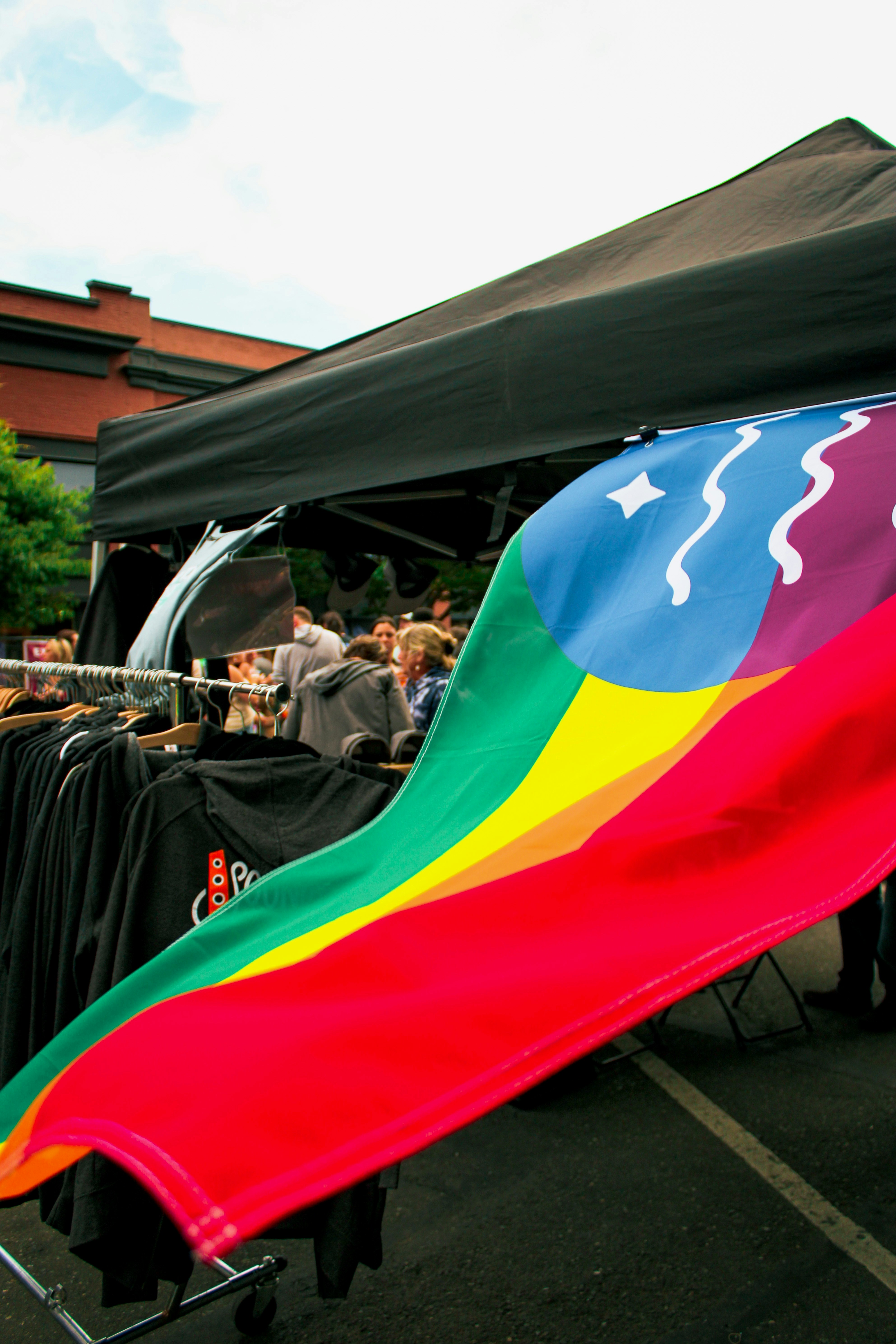 A large rainbow colored kite is on a cart