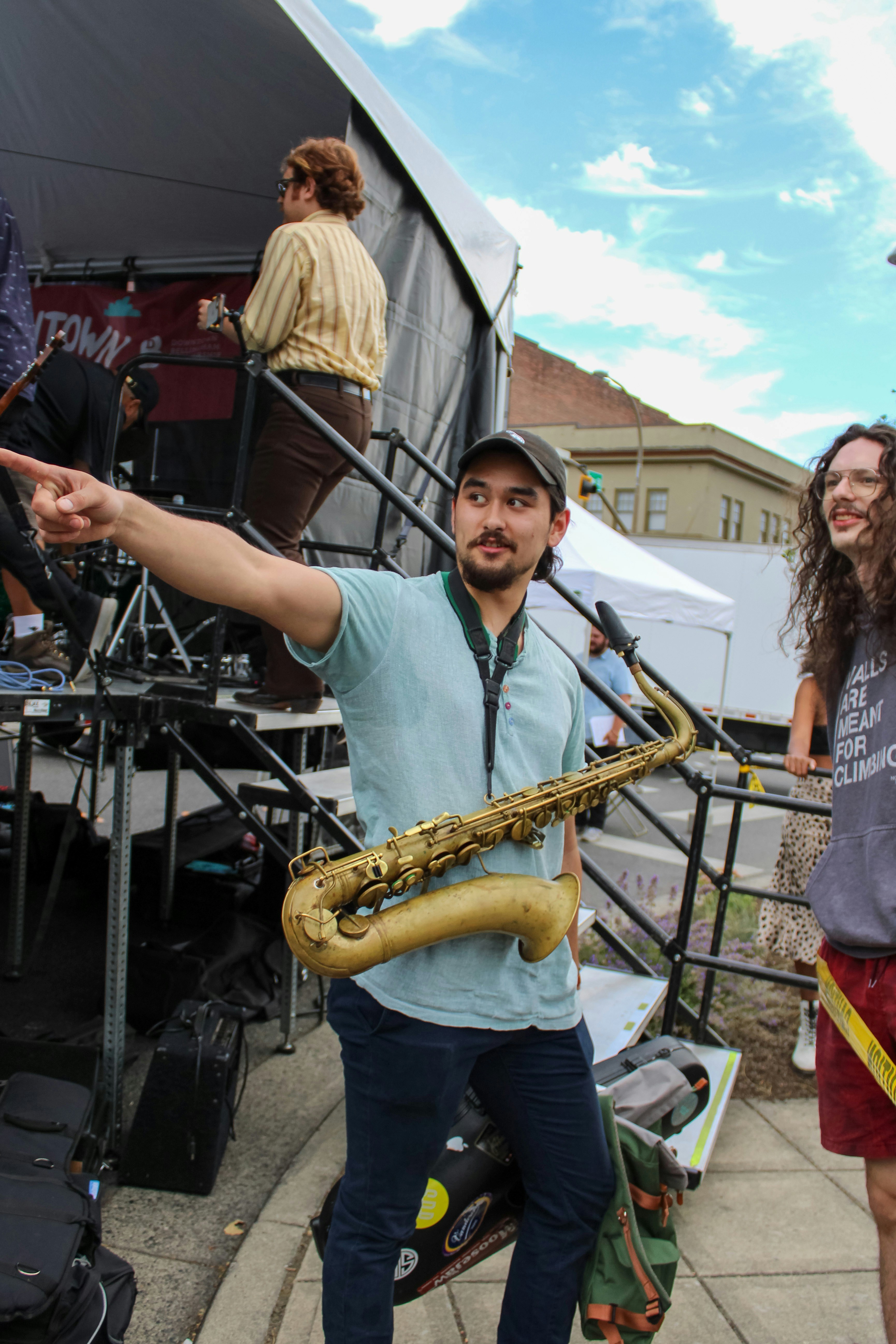 A man playing a saxophone on a sidewalk