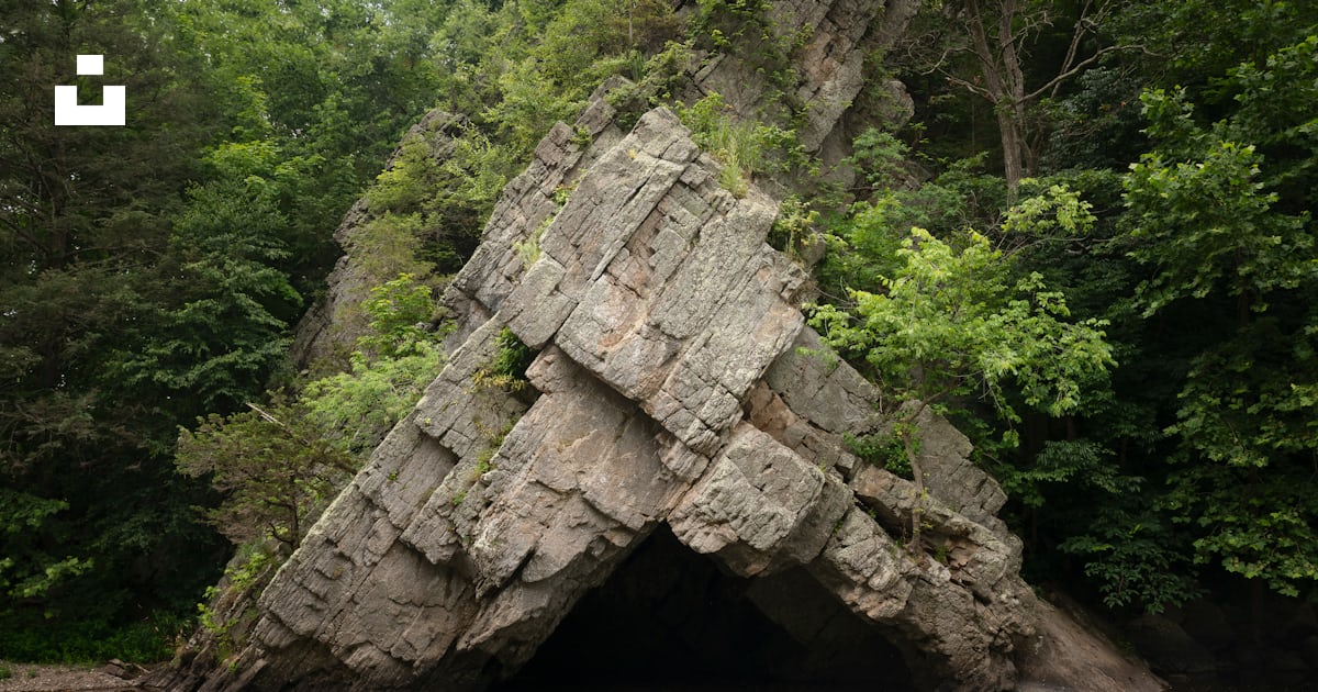 A rock outcropping in the middle of a body of water photo – Free ...