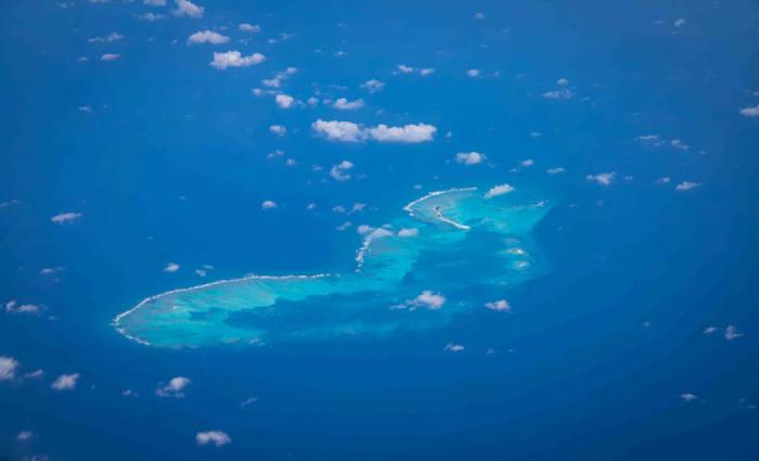 Aerial view of an uninhabited reef-fringed island, similar to West Caicos