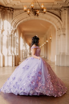 A woman in a purple dress standing in a hallway