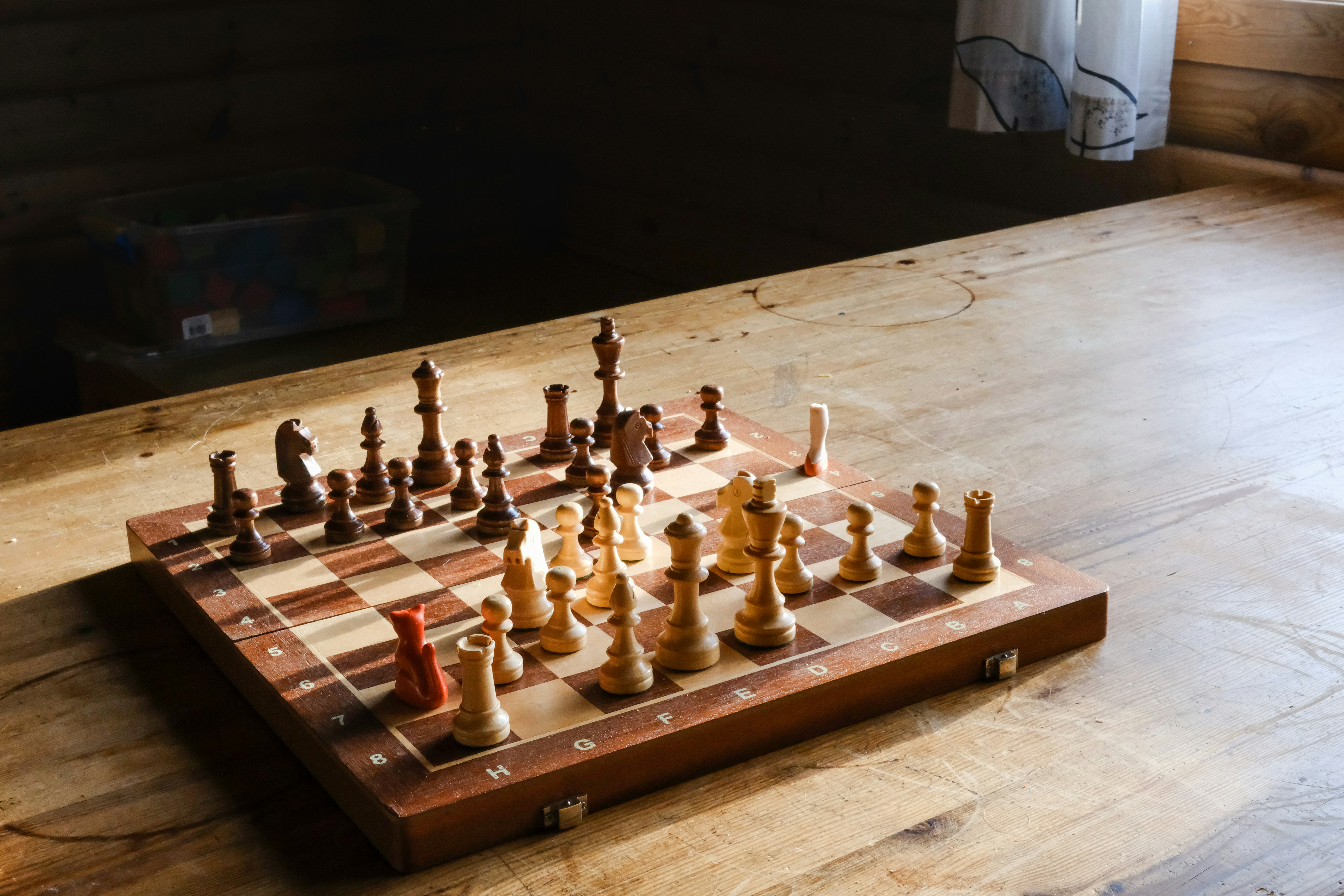 A wooden chess board sitting on top of a wooden floor