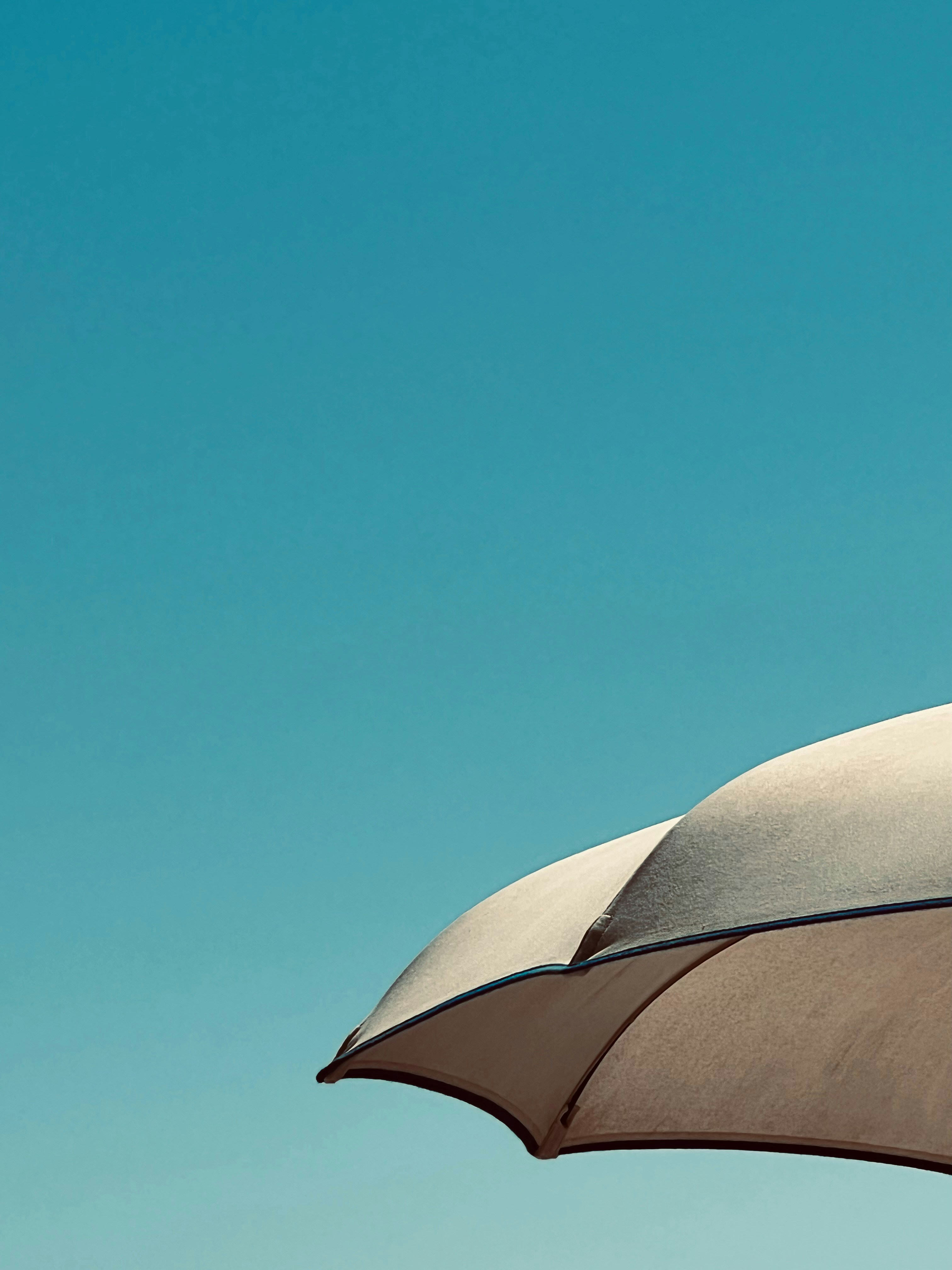 A close up of an umbrella with a blue sky in the background