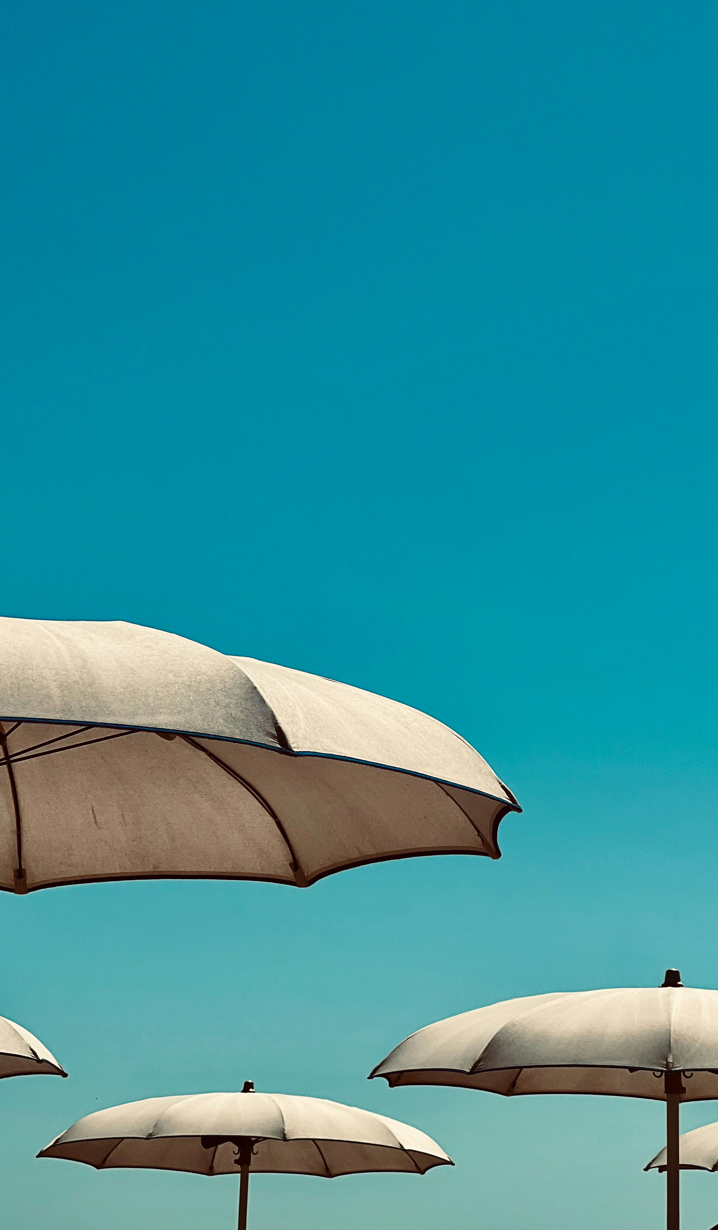 A group of umbrellas sitting on top of a sandy beach