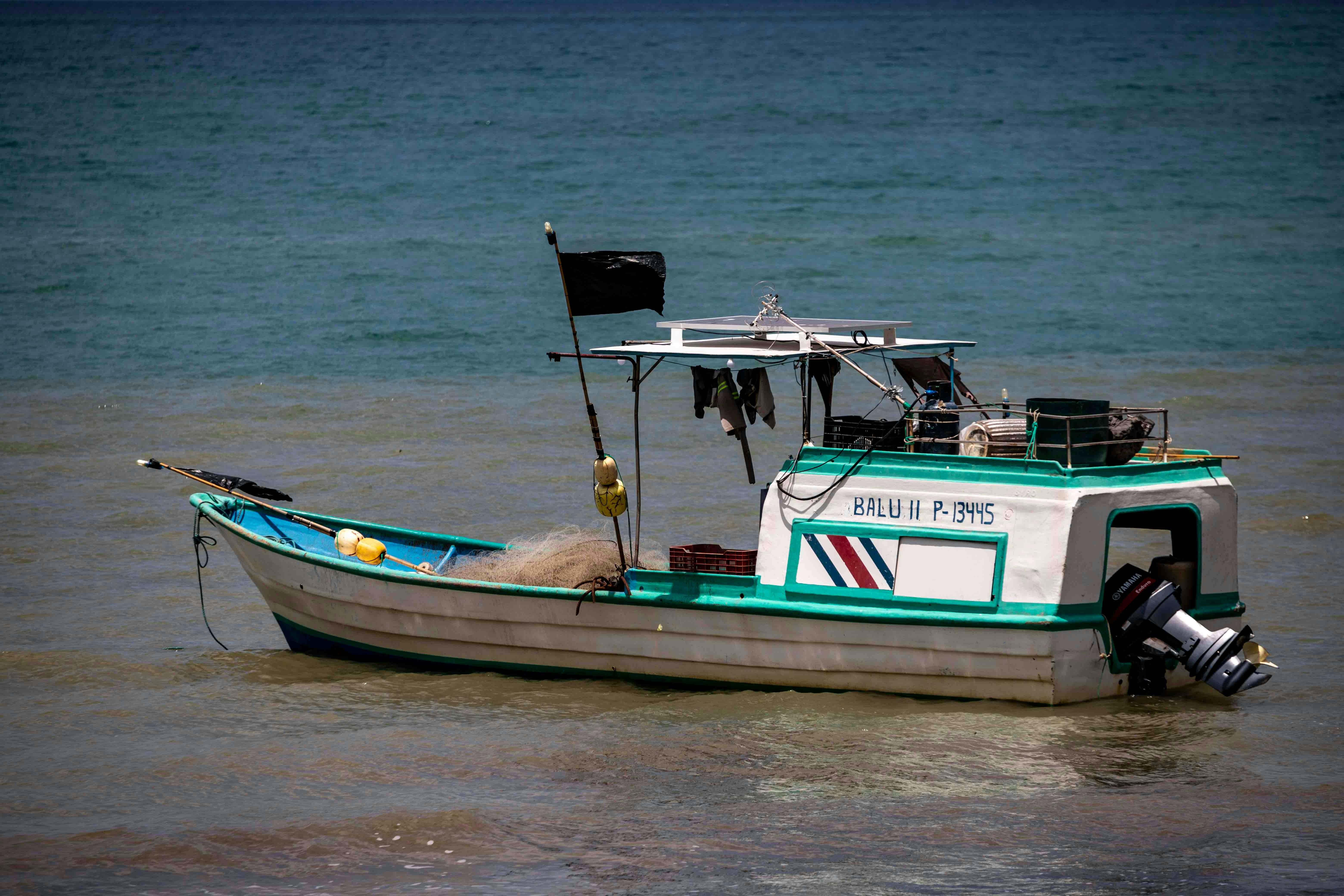 A small boat floating on top of a body of water