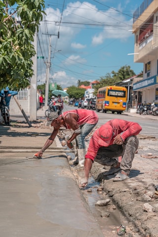 A couple of people that are standing on a sidewalk