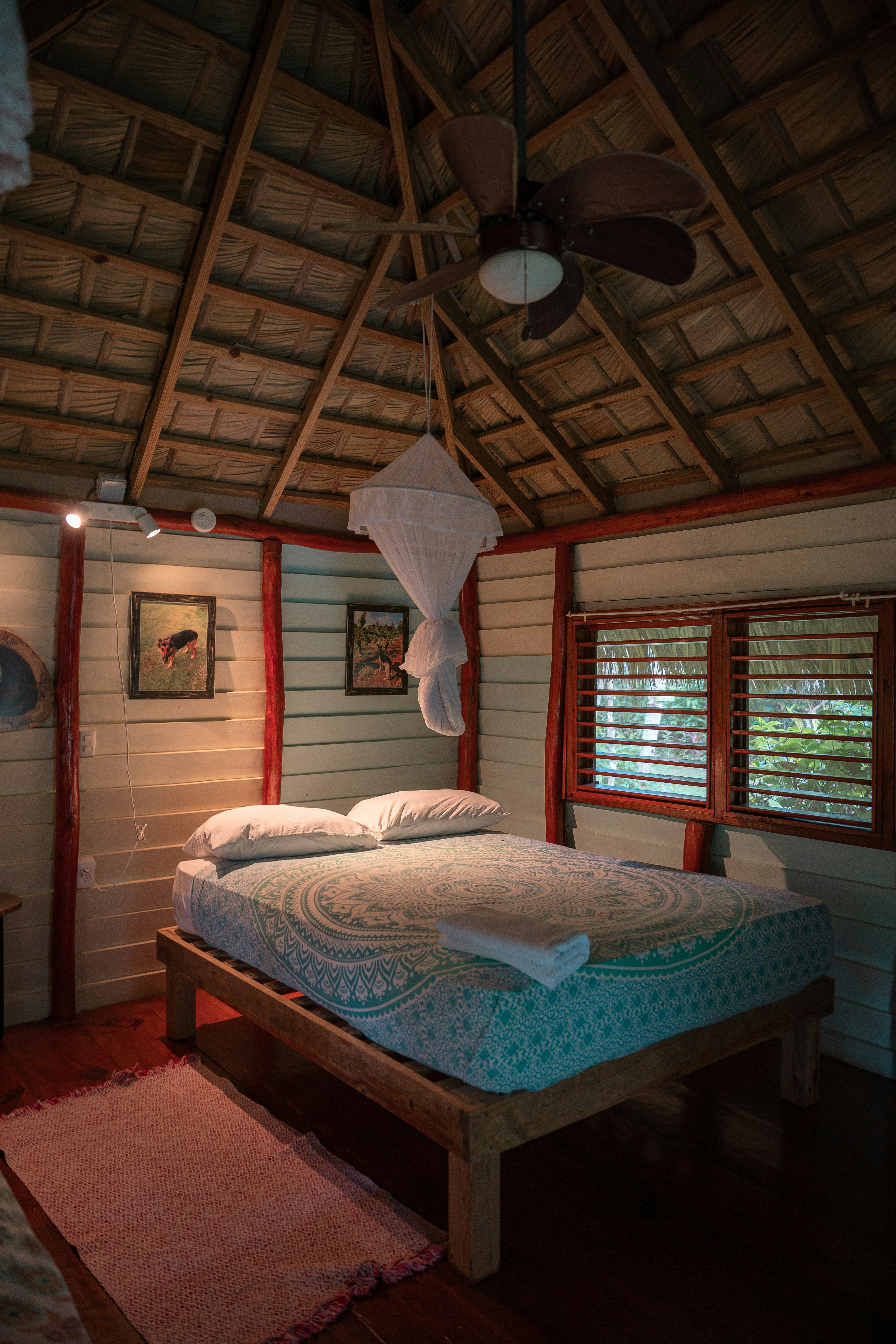 A bedroom with two beds and a ceiling fan