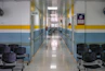 A long hallway with chairs and a clock on the wall