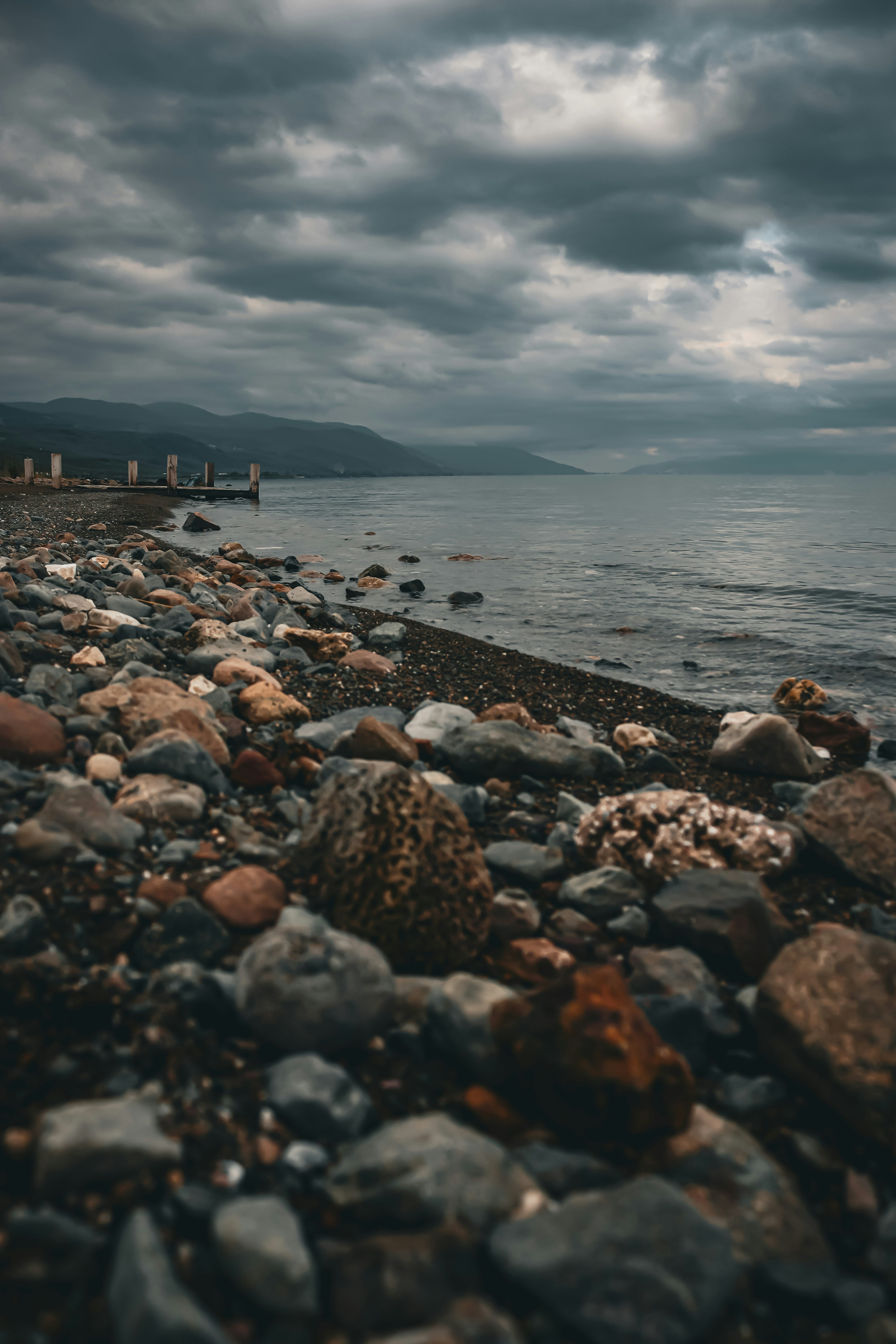 A beach with rocks and water under a cloudy sky