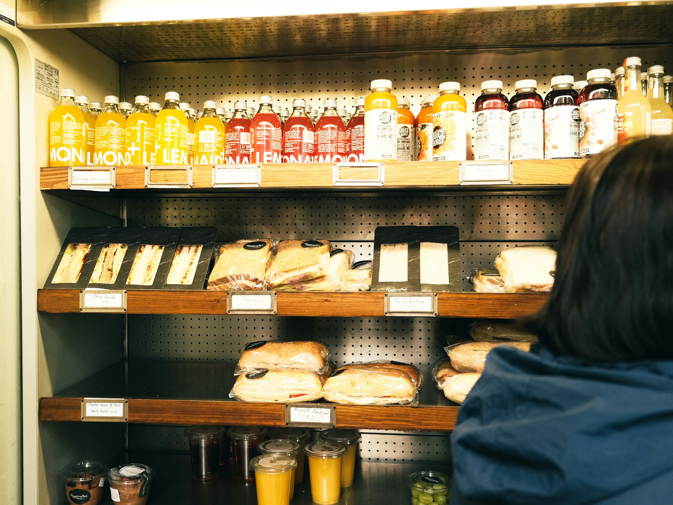 A woman standing in front of a shelf filled with food