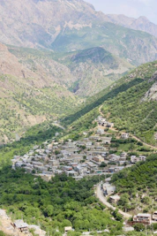 A village nestled in a valley surrounded by mountains