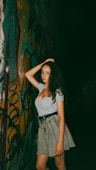 A woman standing in front of a graffiti covered wall