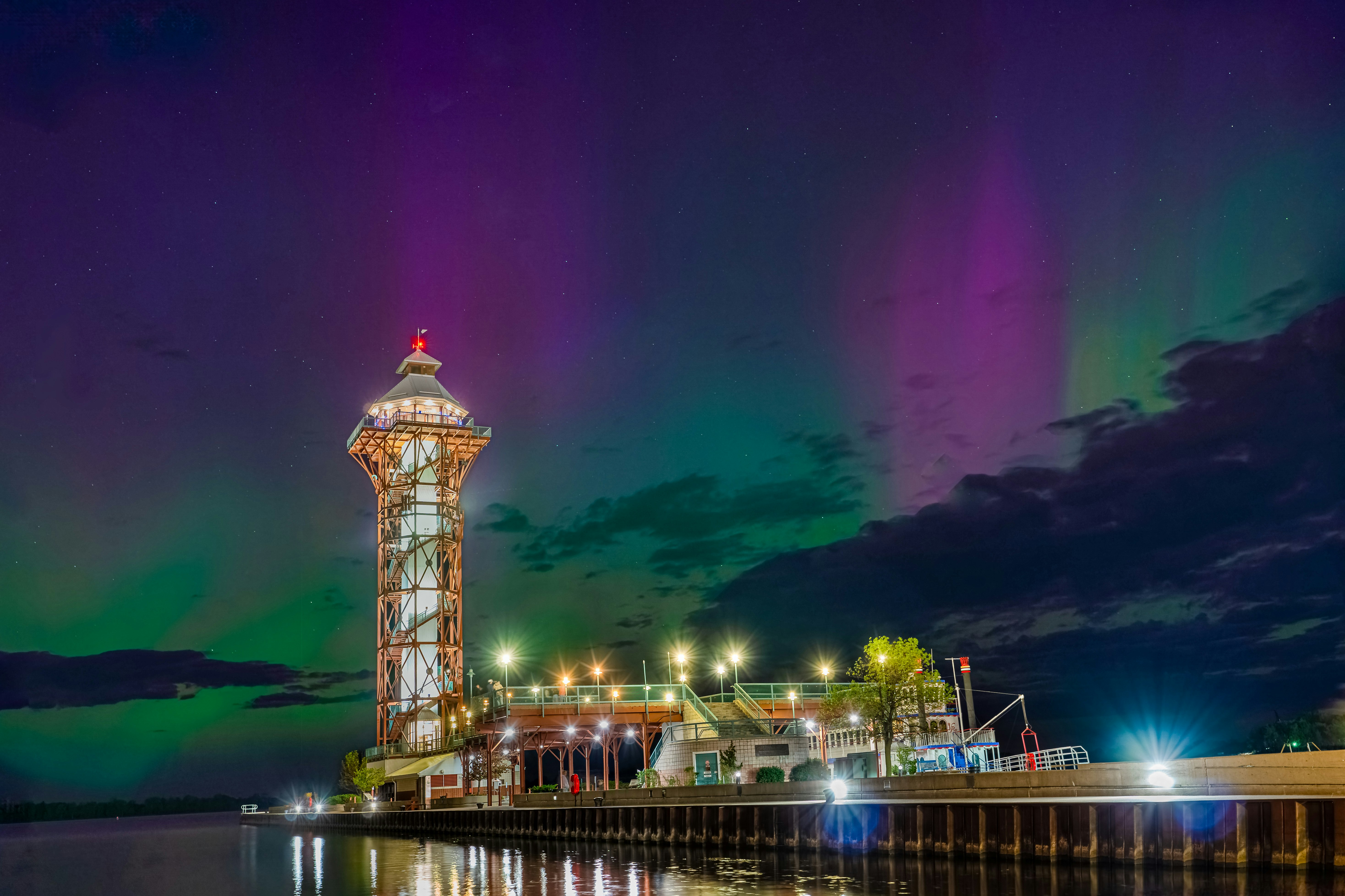 The aurora lights shine brightly over a pier