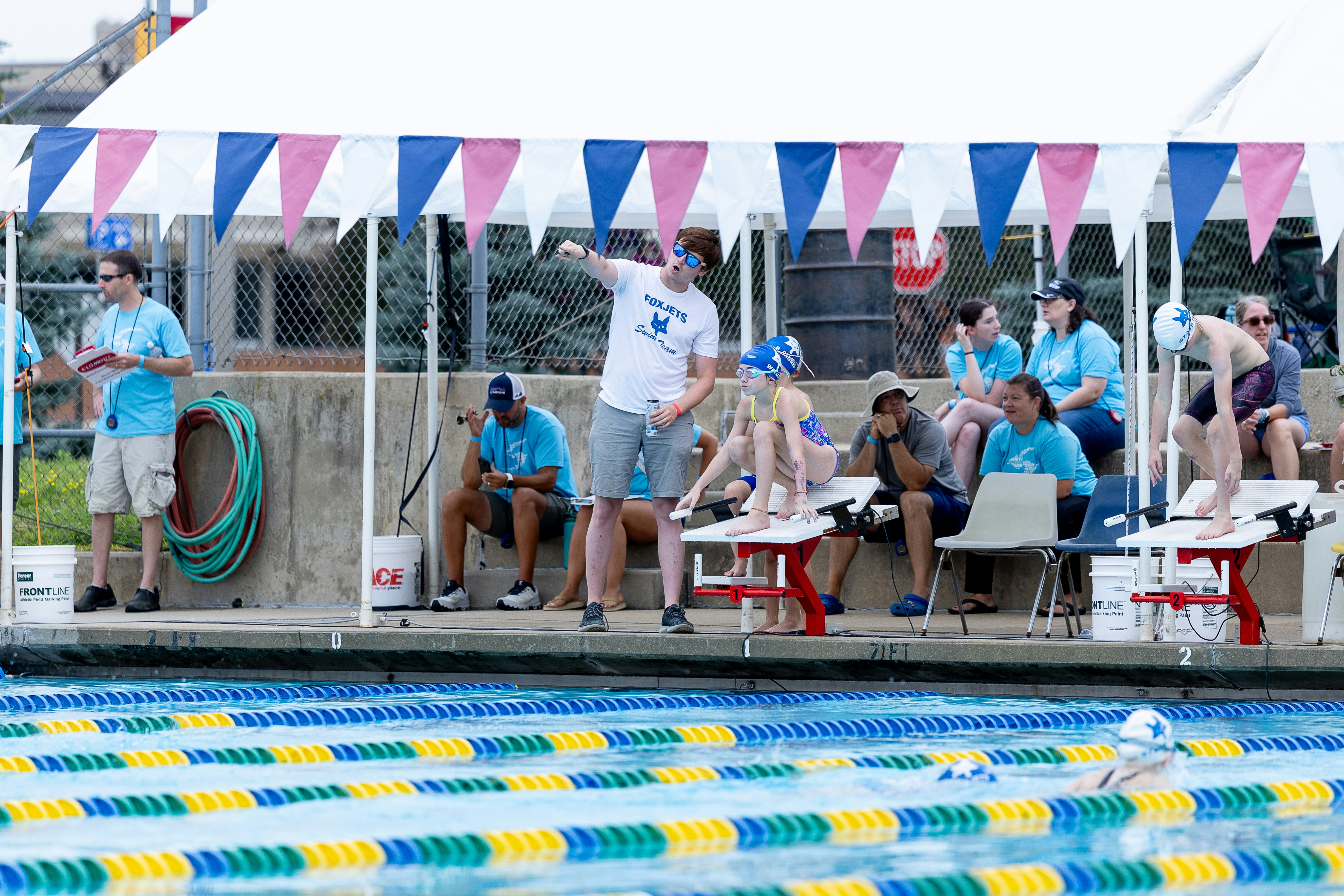 A group of people standing around a swimming pool