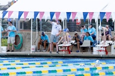 A group of people standing around a swimming pool