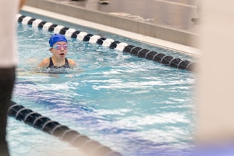 A girl swimming in a pool wearing a swimming cap